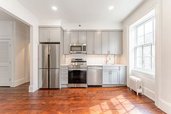 a kitchen with gray cabinets and a wood floor